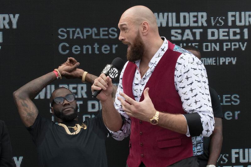 Deontay Wilder, left, reacts as Tyson Fury talks about him during a boxing news conference Tuesday, Oct. 2, 2018, in New York. The pair are slated to square off in a world heavyweight title showdown in Los Angeles on Dec, 1. (AP Photo/Mary Altaffer)