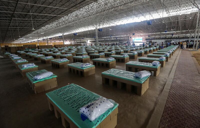 Indian volunteers set up beds made of cardboard as they prepare a Covid care facility which can accommodate around ten thousand Covid-19 patients at the Radha Soami Satsang Beas complex in New Delhi, India.  EPA