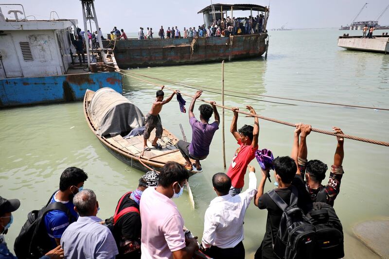 People traverse a rope to board an overcrowded ferry to get home for Eid Al Fitr after government-imposed Covid-19 restrictions on public transport were enforced in Munshiganj, Bangladesh. Reuters