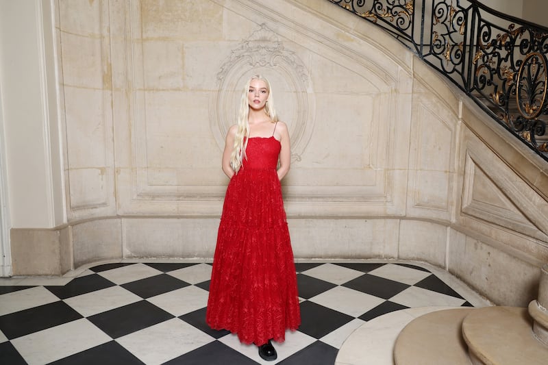 Anya Taylor-Joy at the Christian Dior show wearing a flame red dress