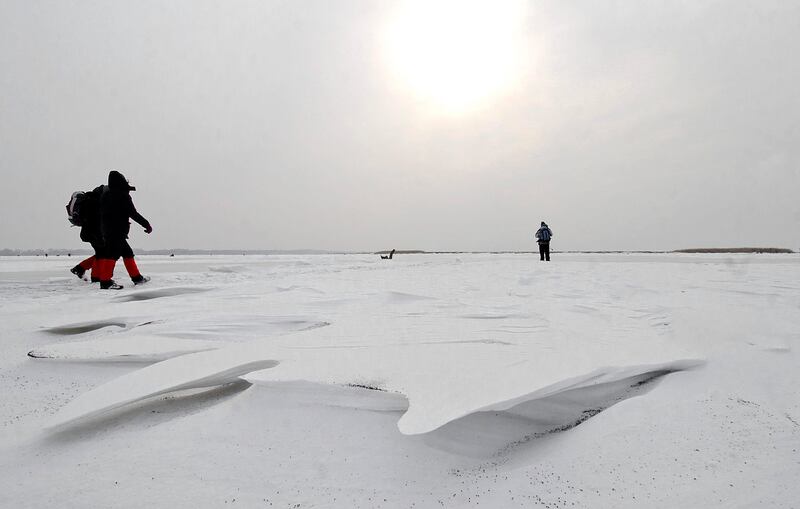 epa03093805 Tourists hike around the frozen Lake Tisza, Hungary's largest artificial lake, near Poroszlo, 136 kms east of Budapest, on 05 February 2012. Freezing cold combined with snowstorms continued to claim lives across Europe, bringing the death toll to more than 280 by Sunday - most of the victims were in Ukraine, where another 30 people died over the weekend.  EPA/ZSOLT CZEGLEDI **HUNGARY OUT** *** Local Caption ***  03093805.jpg