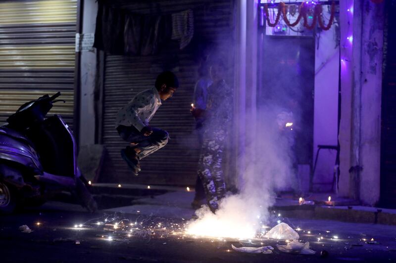 People watch as firecrackers burn during Diwali in New Delhi, India. Reuters