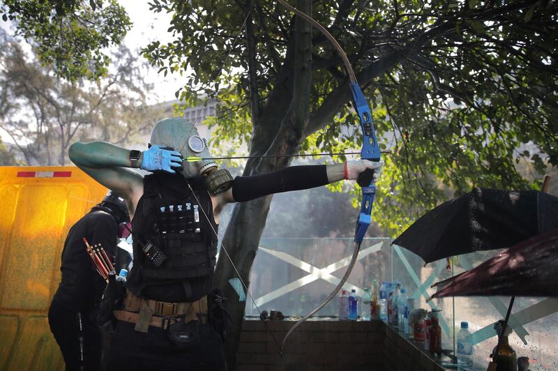 A protester armed with a bow prepares to fire an arrow during a confrontation with police at the Hong Kong Polytechnic University in Hong Kong.  AP