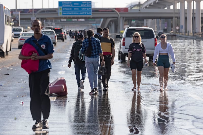 People in Dubai walk from their cars after high floodwaters made the road impassable. Antonie Robertson / The National