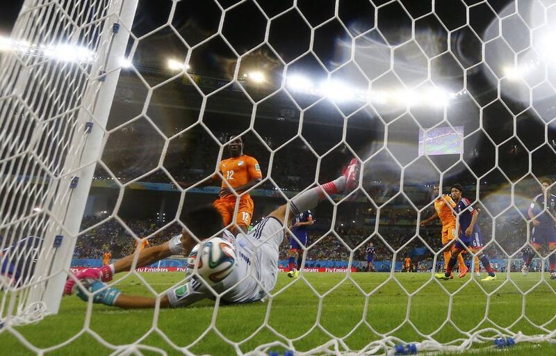 Gervinho (not pictured) scores past Japan’s goalkeeper Eiji Kawashima to put Ivory Coast 2-1 up. Yves Herman / Reuters