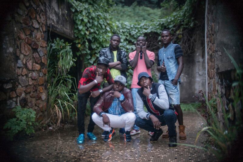 Lionel Fotot, wearing a brown leather jacket and white pants, poses for a photograph with other members of the multi-faith hip-hop crew One Force in Bangui, Central African Republi.