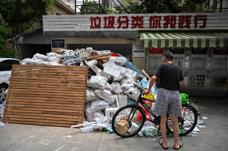 In this photo taken on July 11, 2019, a man looks at piled up garbage at a housing complex in the former French concession in Shanghai. Shanghai on July 1 launched China's most ambitious garbage separation and recycling programme ever, as the country confronts a rising tide of trash created by increasingly consumptive ways. But the programme is the talk of China's biggest city for other reasons as well: confusion over rules and fines for infractions, and thousands of volunteers inspecting citizens' private garbage each day.
 - TO GO WITH: China-environment-waste-recycling, FOCUS by Lianchao LAN and Dan MARTIN
 / AFP / HECTOR RETAMAL / TO GO WITH: China-environment-waste-recycling, FOCUS by Lianchao LAN and Dan MARTIN
