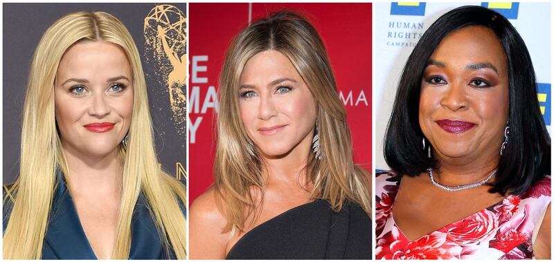 FILE- This combination of file photos show actresses Reese Witherspoon at the 69th Primetime Emmy Awards in Los Angeles, left, Jennifer Aniston at a screening of "Office Christmas Party" in New York and Shonda Rhimes at the 2015 Human Rights Campaign Gala Dinner in Los Angeles. Witherspoon, Rhimes and Aniston are among hundreds of Hollywood women who have formed an anti-harassment coalition called Time's Up. (AP Photo/File)