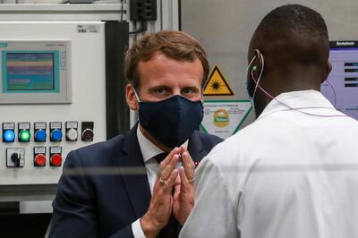 French President Emmanuel Macron wears a face mask, as he speaks to a worker during a visit at the Valeo manufacturer plant, in Etaples, northern France, Tuesday May 26, 2020. France's government is injecting more than 8 billion euros ($8.8 billion) to save the country's car industry from huge losses wrought by virus lockdowns, and wants to use the crisis to make France the No. 1 producer of electric vehicles in Europe. (Ludovic Marin, Pool via AP)