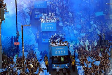 Manchester City players and staff are cheered on by thousands of fans during their open top bus parade. Press Association