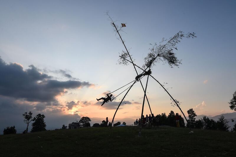 A youth plays on a swing, popularly known as the 'Dashain Ping', during the Hindu festival of 'Dashain' in Changu Naryan on the outskirts of Kathmandu.  AFP