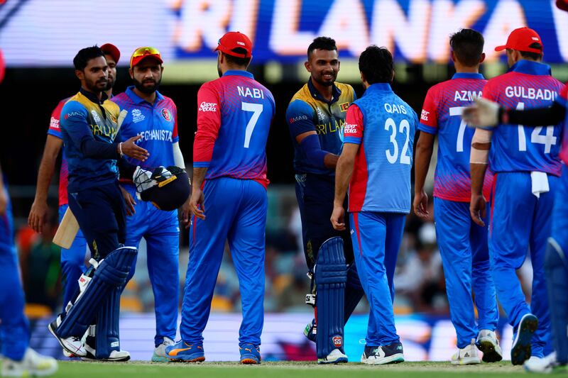 Sri Lanka's Captain Dasun Shanaka (L) and Dhananjaya de Silva (C) shake hands with Aghanistan players after their win during the ICC men's Twenty20 World Cup 2022 cricket match between Afghanistan and Sri Lanka at The Gabba on November 1, 2022 in Brisbane.  (Photo by Patrick HAMILTON  /  AFP)  /  -- IMAGE RESTRICTED TO EDITORIAL USE - STRICTLY NO COMMERCIAL USE --
