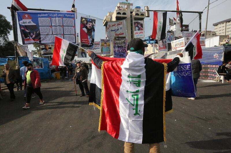 An Iraqi protester clad with the national flag takes part in anti-government demonstrations at Tahrir square in the capital Baghdad, on December 30, 2019. / AFP / SABAH ARAR
