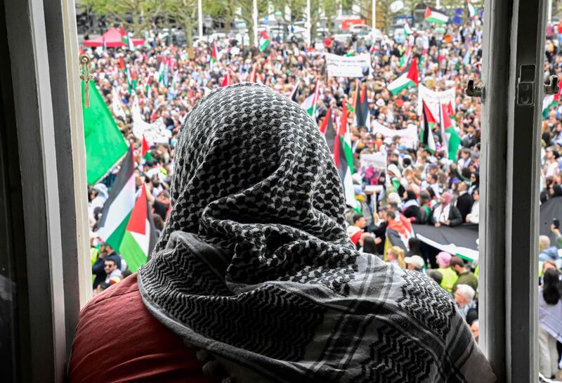 A man wearing a keffiyeh looks out at protesters. AFP