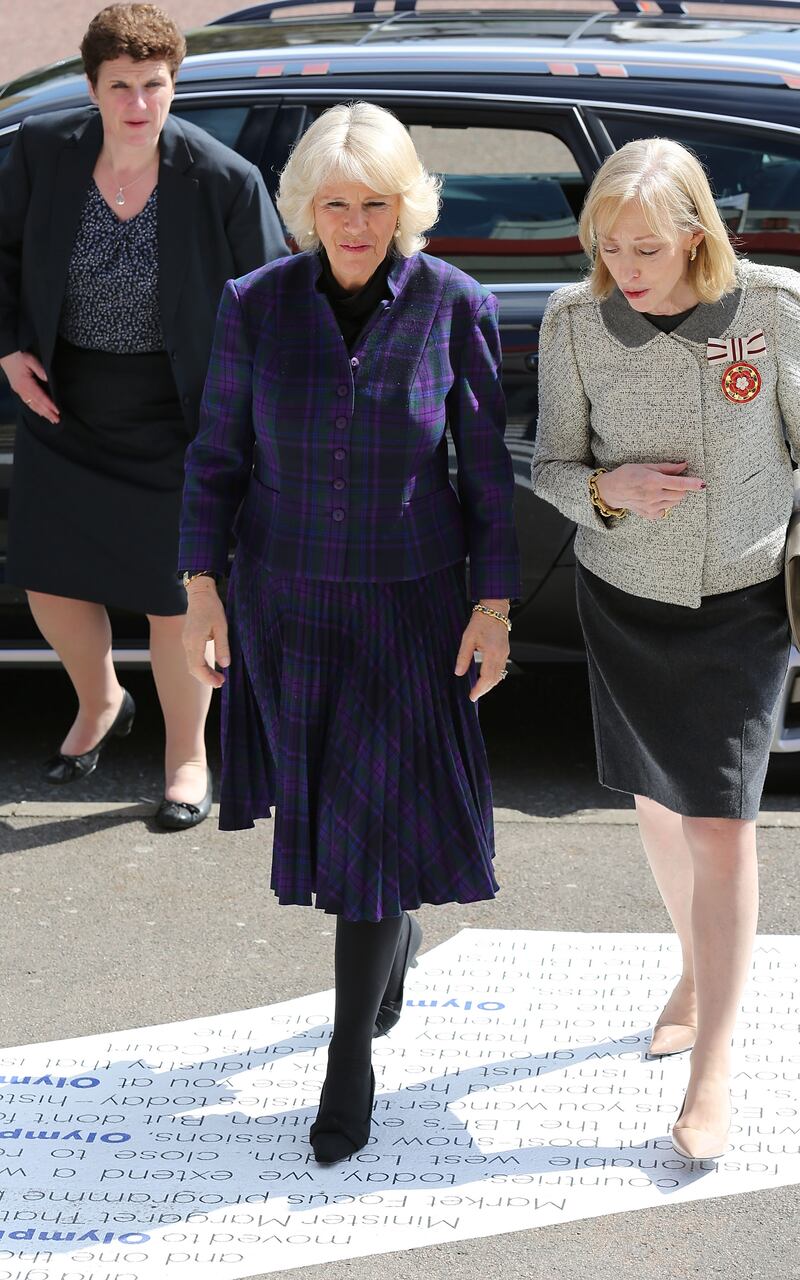 The queen consort, in a purple tartan jacket and skirt, attends an official visit to The London Book Fair at Earls Court on April 9, 2014. Getty Images