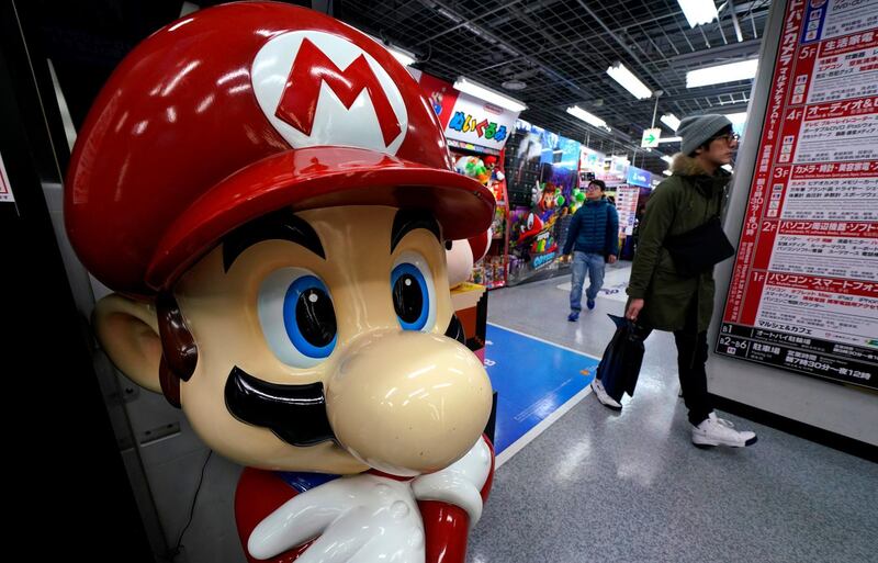 A Super Mario figure greets shoppers at an electronics store in Tokyo, Wednesday, Jan. 31, 2018. Japanese video-game maker Nintendo says its net profit jumped 31 percent in April-December from a year earlier, helped by the popularity of its Switch hybrid game machine. (AP Photo/Shizuo Kambayashi)
