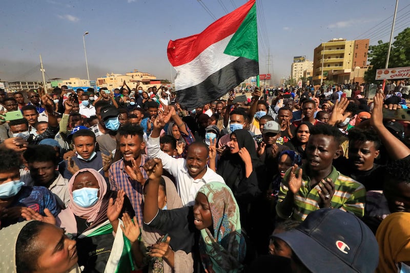 Sudanese demonstrators wave the national flag on the streets of the capital, Khartoum.