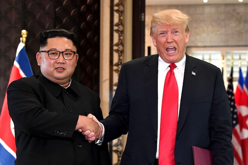 (FILES) In this file photo taken on June 12, 2018, US President Donald Trump (R) and North Korea's leader Kim Jong Un shake hands following a signing ceremony during their historic US-North Korea summit, at the Capella Hotel on Sentosa island in Singapore.
 North Korea has condemned the United States over its latest sanctions measures, warning the policy could "block the path to denuclearization on the Korean peninsula forever". The warning from the North on Sunday, December 16, 2018 came days after the US said it was imposing sanctions on three senior North Korean officials over human rights abuses.  / AFP / SAUL LOEB
