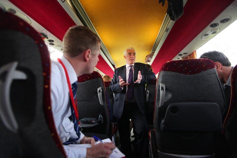 Mr Darling talks to reporters on the Labour Party election tour bus in 2010