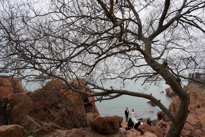 A couple pose for wedding photos along the coastline of Qingdao in eastern China's Shandong province. AP