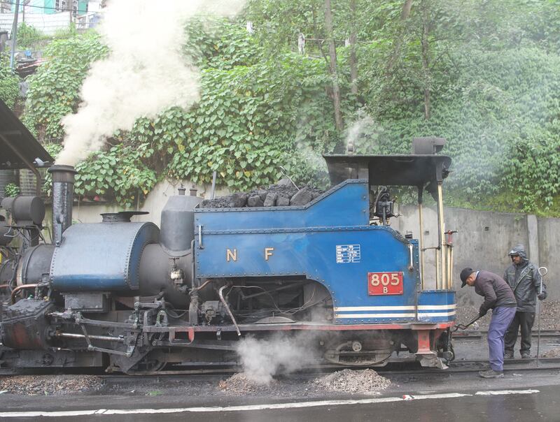 Railway workers prepare a steam engine for its journey along the 90km circuit