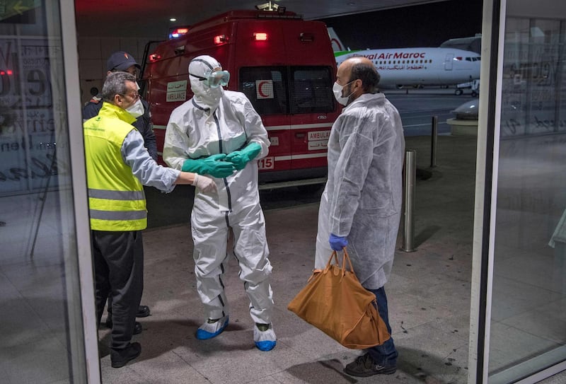 Moroccan health workers scan passengers arriving from Italy in Casablanca.  AFP