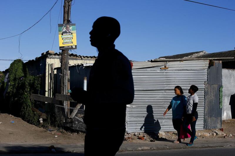 South Africans walk past an election poster for the ruling party African National Congress (ANC) in Cape Town, South Africa. Political analysts indicate the ruling party African National Congress (ANC) will sustain massive losses this election due to the multiple scandals revolving around its president Jacob Zuma. Nic Bothma / EPA / March 28, 2014