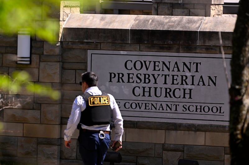 A police officer walks by an entrance to The Covenant School. AP