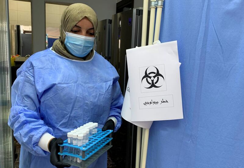 A doctor carries samples before analysing them to ensure they are not infected with Covid-19 at a medical center in Misrata, Libya. Reuters