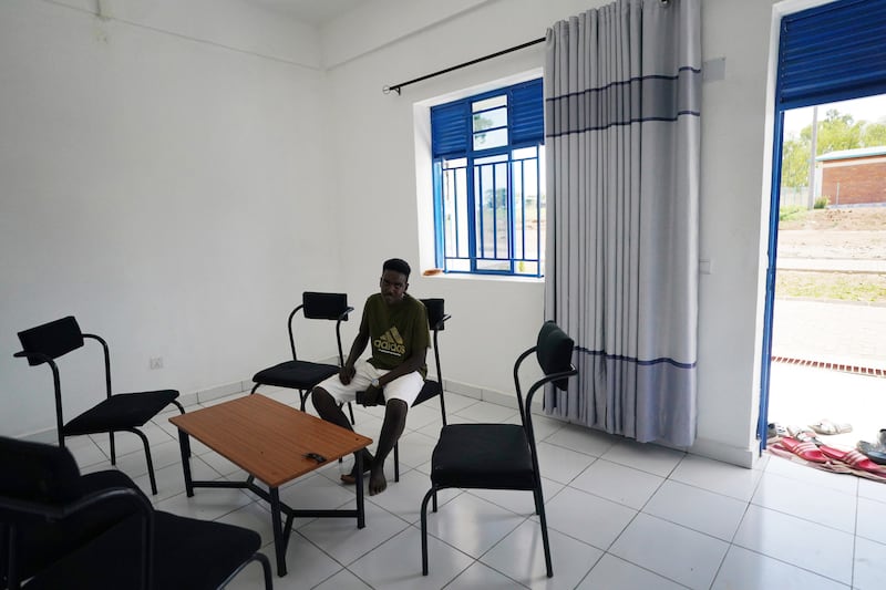 A resident sits in a communal room in the Gashora Refugee Camp Transit Centre. The camp is designed to provide short-term accommodation for people evacuated from Libya after fleeing persecution from a number of countries. PA