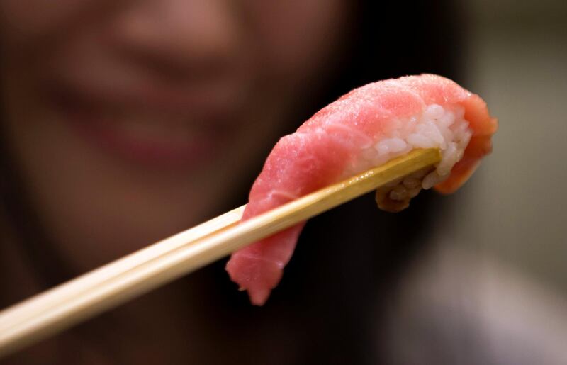 TOKYO, JAPAN - JANUARY 05:  A customer eats a piece of tuna sushi inside  one of the company's Sushi Zanmai sushi restaurants after the year's first auction at Tsukiji Market on January 5, 2017 in Tokyo, Japan. Kiyomura Co. bid the highest priced tuna weighing 212 kilogram (467.38 pound) for 74.2 million yen ($637,155) at the year's first auction.  (Photo by Tomohiro Ohsumi/Getty Images)