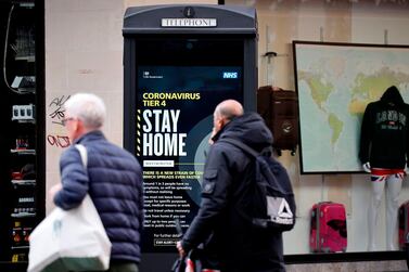 Pedestrians walk past a Covid-19 Tier 4 information sign in central London. Adam Marshall of the British Chambers of Commerce urged the government to "move quickly" on the distribution of the new vaccine. AFP