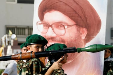FILE PHOTO: A Hezbollah member carries a mock rocket next to a poster of the group's leader Sayyed Hassan Nasrallah during a festival organized by the group to commemorate last year's war with Israel, in Sidon, southern Lebanon, July 22, 2007. REUTERS/Ali Hashisho/File Photo