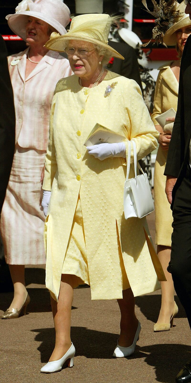 Queen Elizabeth II, wearing yellow, attends the first day of Royal Ascot on June 15, 2004, in Berkshire, England. Getty Images