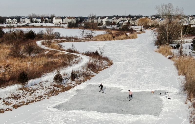 Ice hockey players practise their skills on a rink they created by clearing snow from the surface of a frozen pond in Illinois, US. The northern states are in the grip of a cold snap that has brought up to 60cm of snow. EPA