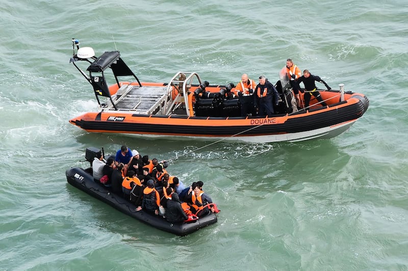 This handout photograph taken and released by the French Marine Nationale on August 5, 2019 shows migrants sitting in an inflatable dinghy rescued by French coast guards while trying to cross the Channel between France and Britain, off the coast of Graveline and the Cap Griz-Nez, on August 5, 2019. Twenty migrants trying to cross the Channel were rescued on the morning of August 5, 2019 while their run out of fuel, announced the Maritime Prefecture of the Channel and the North Sea. Some of them were in a state of mild hypothermia and shock, the prefecture said in a statement. They were taken care of by firefighters and border police. - RESTRICTED TO EDITORIAL USE - MANDATORY CREDIT "AFP PHOTO/ MARINE NATIONALE" - NO MARKETING NO ADVERTISING CAMPAIGNS - DISTRIBUTED AS A SERVICE TO CLIENTS
 / AFP / MARINE NATIONALE / - / RESTRICTED TO EDITORIAL USE - MANDATORY CREDIT "AFP PHOTO/ MARINE NATIONALE" - NO MARKETING NO ADVERTISING CAMPAIGNS - DISTRIBUTED AS A SERVICE TO CLIENTS
