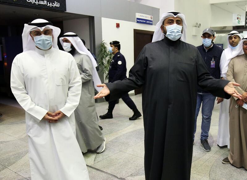 Kuwaiti health minister Sheikh Basel al-Sabah (R) speaks to the press at Sheikh Saad Airport in Kuwait City, as Kuwaitis returning from Iran wait before being taken to a hospital to be tested for coronavirus. AFP