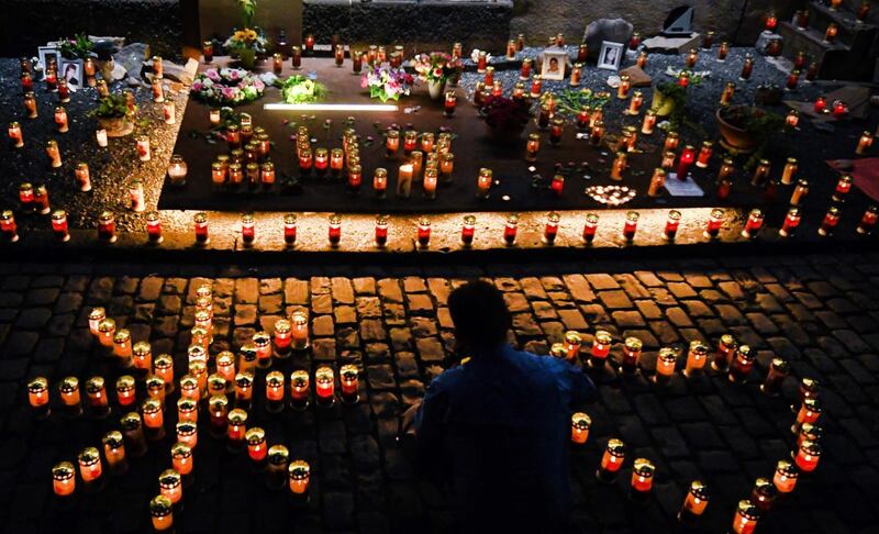 Candles, flowers and portraits are displayed at the Love Parade Memorial in Duisburg, western Germany, on the eve of the day marking 10 years after a mass panic broke out among ravers in a crowded tunnel at the Love Parade grounds, leaving 21 young people dead.  AFP