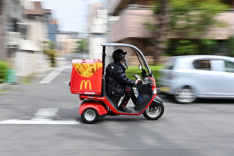 A man working for McDonald's delivery service rides a motorcycle in Tokyo's Taito district on March 26, 2019. / AFP / CHARLY TRIBALLEAU

