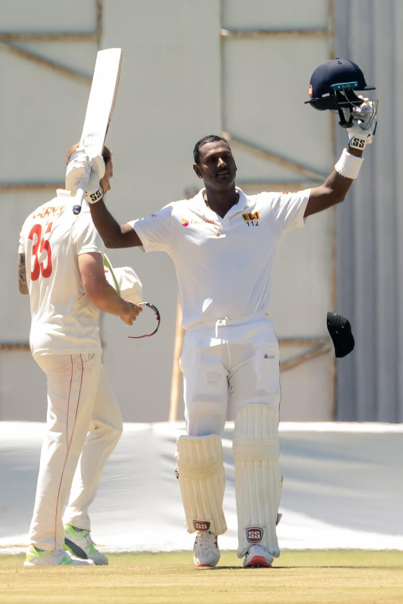 Sri Lanka's Angelo Mathews (R) celebrates after scoring a century (100 runs) during the fourth day of the first Test cricket match between Zimbabwe and Sri Lanka at the Harare Sports Club in Harare on January 22, 2020. (Photo by Jekesai NJIKIZANA / AFP)