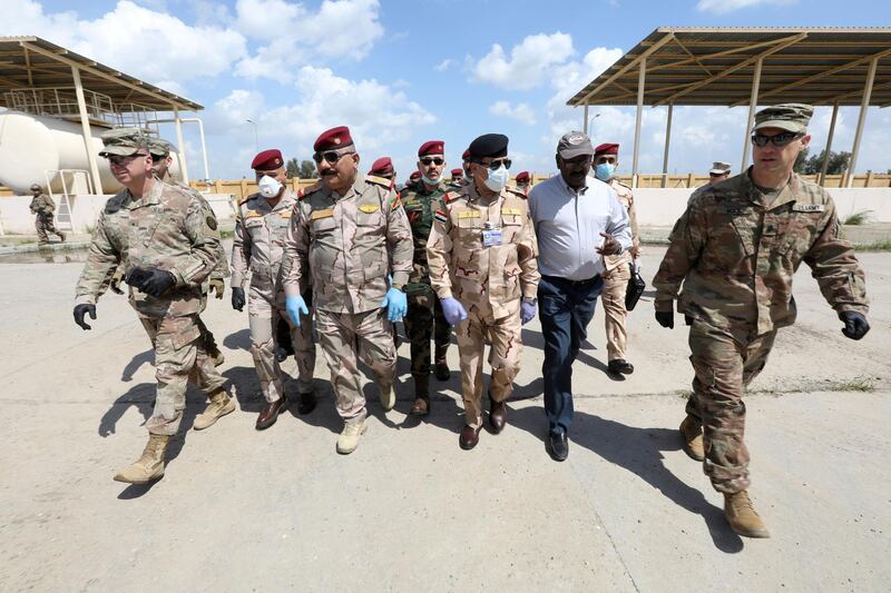 Iraqi Army officers wear protective masks, following the outbreak of coronavirus, as they walk with US officers before a handover ceremony of K-1 airbase from US-led coalition forces to Iraqi Security Forces, in Kirkuk governorate, Iraq. Reuters