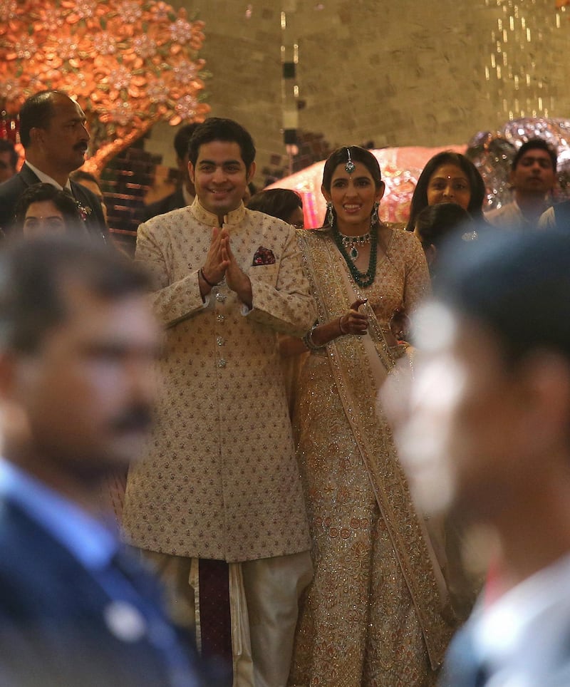 Akash Ambani and his fiancee Shloka Mehta greet guests at the wedding ceremony of Akash's sister Isha Ambani. Reuters