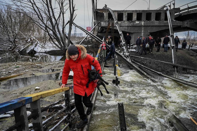 Civilians cross a river on Kiev's northern front. AFP