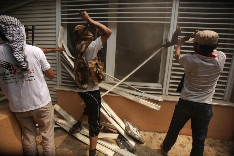 Rebels break into a living room at Libyan leader Moamer Kadhafi's Bab al-Aziziya compound in Tripoli on August 24, 2011, as fighting rages in the area a day after it was captured by opposition forces with loyalist troops staging a fightback and the strongman boasting he went walkabout.  AFP PHOTO/PATRICK BAZ
 *** Local Caption ***  670459-01-08.jpg