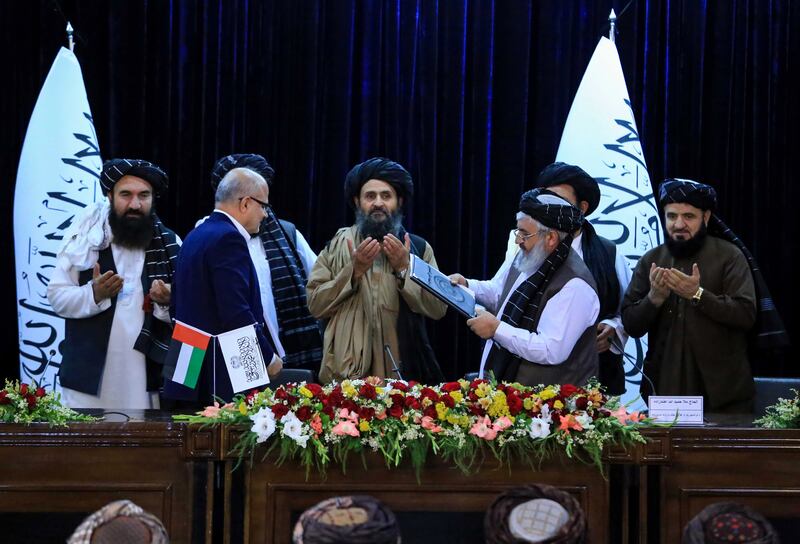 Abdul Ghani Baradar, Taliban deputy prime minister, exchanges documents with Razzaq Aslam, a UAE aviation officer, during a ceremony in Kabul. EPA