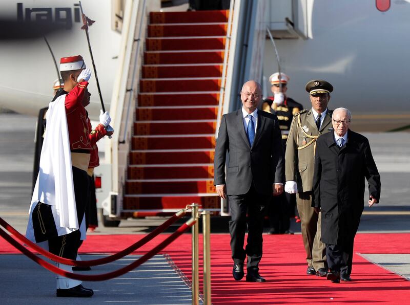 Iraq's President Barham Salih walks next to his Tunisian counterpart Beji Caid Essebsi upon his arrival at Tunis-Carthage International Airport to attend the Arab Summit.  REUTERS