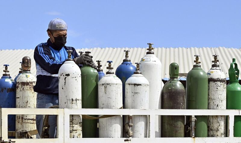 An employee of Valle Alto Medical Oxygen plant works with oxygen tanks in Arbieto municipality, 50 km from Cochabamba.   AFP