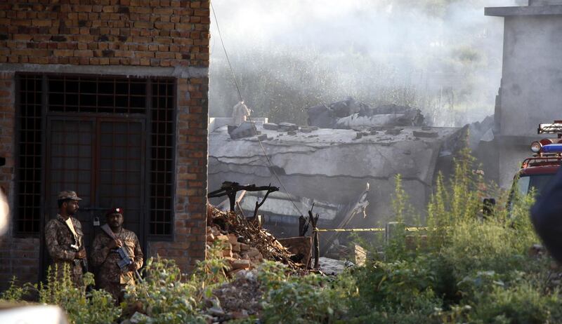 Security officials inspect the scene of a military plane crash. EPA