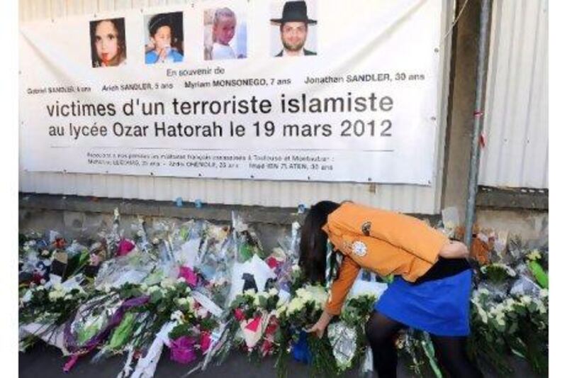 The killings by Mohamed Merah shocked France and led to an outpouring of public grief, including floral tributes at the Ozar Hatorah Jewish school where four of the victims died. Above, a French scout leaves flowers at the end of a march by people from all faiths yesterday in the city of Toulouse.