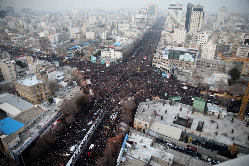 Iranians march behind a vehicle carrying the coffins of Qassem Suleimani and others as they pay homage in the northeastern city of Mashhad. AFP